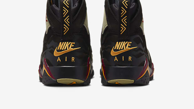 Rear view of black and gold Air Jordan shoes.